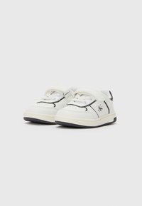 Baskets blanches pour tout-petits avec des bordures noires, une sangle Velcro, des lacets et le logo "Calvin Klein" sur le côté, présentées sur un fond blanc.