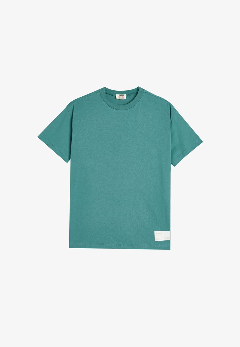 Teal bomulds T-shirt med korte ærmer, rund hals og et rektangulært label forneden, der viser teksten "havet."