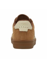 Sneaker in suede marrone con fodera in cotone e suola in gomma, vista dal retro con il logo K-Swiss sul tallone.