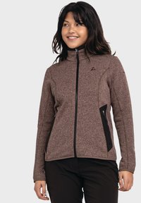 Braune strukturierte Zip-Jacke mit hohem Kragen, schwarzen Akzentpaneelen, Seitentaschen und kontrastierenden Nähten.