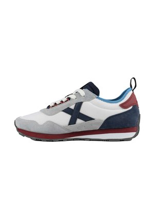 Zapatilla baja con ante gris y malla blanca, con detalles en azul marino y granate, cordones blancos y pestaña para tirar en el talón.