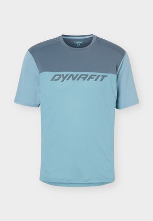 Hellblaues kurzärmeliges Sportshirt mit dunklerem blauem Oberteil und „DYNAFIT“-Logo quer über der Brust.