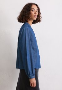 Blaue Denim-Hemd mit durchgehender Knopfleiste, rundem Kragen und langen Ärmeln. Verfügt über einen lässigen Schnitt und geraffte Bündchen. Minimalistisches Design.