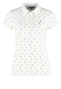 Bílá polokošile se vzorem malých černých kotev a hvězdiček, krátké rukávy a tříknoflíkovou légou. Měkký bavlněný materiál.