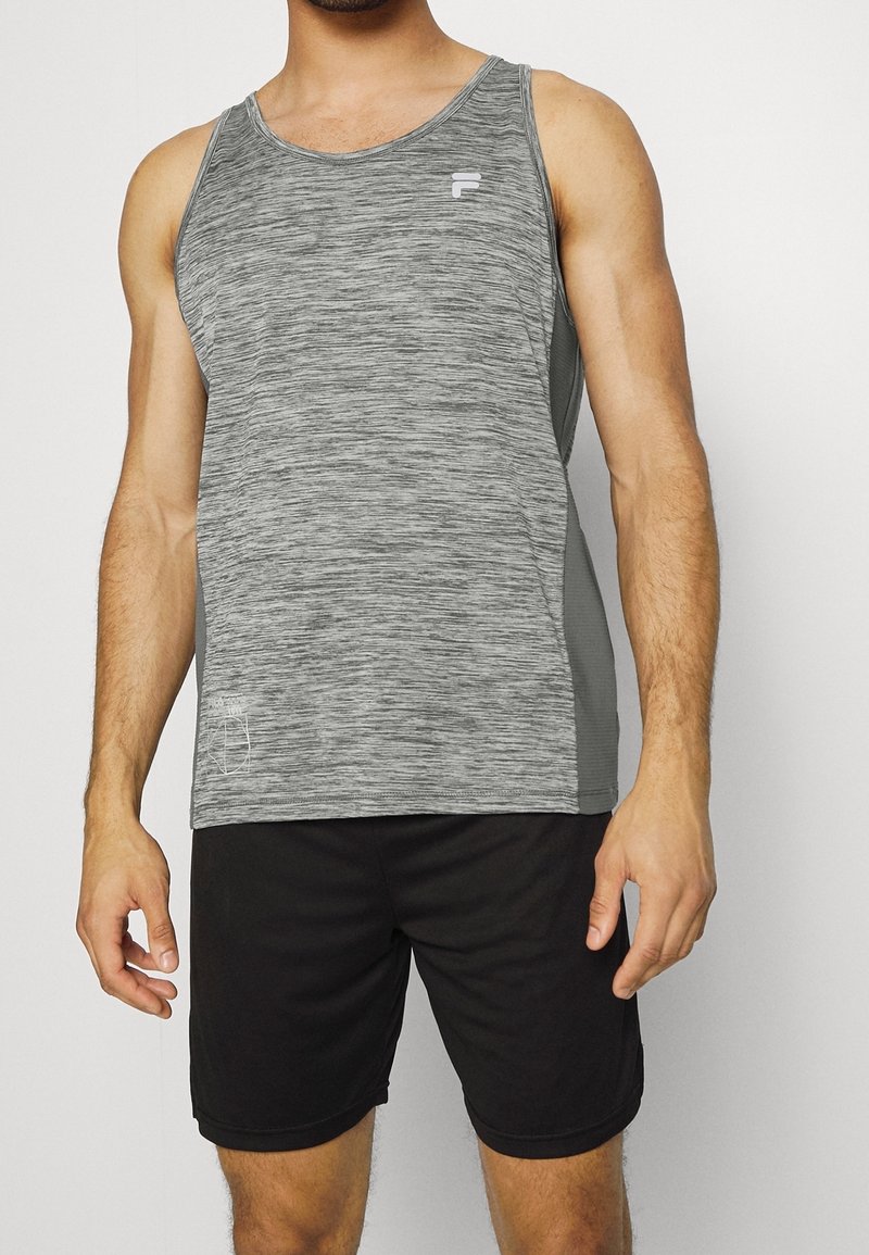 Canottiera sportiva grigia con texture mélange, pannelli laterali in grigio scuro e un piccolo logo bianco sul petto, abbinata a pantaloni corti neri.
