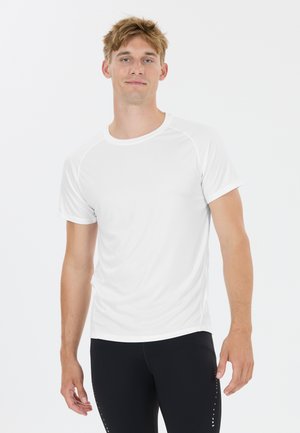 Mand iført en ensfarvet hvid kortærmet sportstrøje og sorte tætsiddende leggings mod en hvid baggrund.