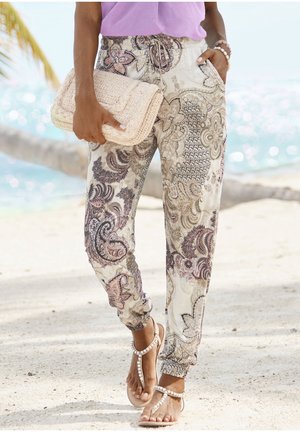 Pohodlné volné kalhoty typu jogger v krémové barvě s fialovými paisley vzory. Mají elastický pás, manžety a boční kapsy.