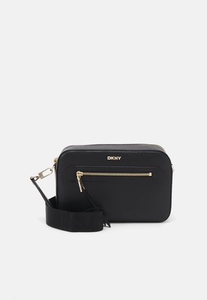 Black DKNY crossbody bag made of textured material, featuring a gold zipper detail, logo on the front, and a detachable strap.