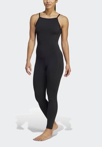 Bodysuit de athleisure negro con tirantes finos, con un diseño ajustado y textura sin costuras, ideal para ropa deportiva.