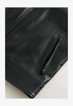 Giacca in pelle nera con una texture liscia, dotata di zip evidenti e un design strutturato. Accentuata da una tasca angolata.