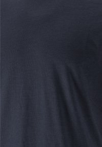 Mörk marinblå bomullstyg med en slät textur, som visar en subtil glans och lätt stretch, lämplig för avslappnad klädsel.