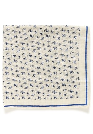 Tissu beige clair avec de petits motifs floraux bleus et une fine bordure rayée bleue le long des bords.