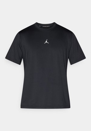 Camiseta negra de manga corta hecha de tejido liso, con un logo Jumpman blanco centrado en el pecho. Diseño sencillo con cuello redondo.
