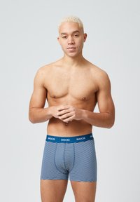 Striped boxer shorts in navy and white, featuring a snug fit, elastic waistband with "SNOCKS" branding, and soft fabric texture.