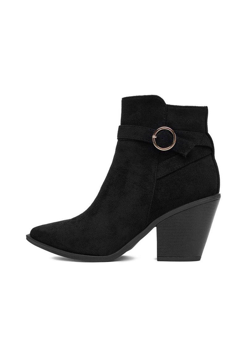 Czarne zamszowe botki za kostkę z wydłużonym noskiem, słupkiem i ozdobnym paskiem z okrągłą złotą klamrą po zewnętrznej stronie.