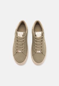 Olivgröna sneakers i slätt material, med en texturerad sula av jute och detaljer i guld. Skosnörena matchar skons färg.