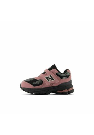 Baskets New Balance 2002R noires et roses avec détails en mesh et double scratch, présentées de profil sur fond blanc.