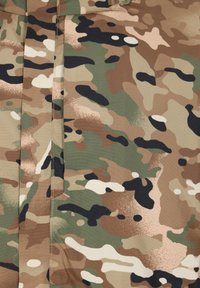 Kamouflage-tyg med nyanser av grönt, brunt och beige. Mönstret inkluderar oregelbundna former och fläckar med mörka accenter.