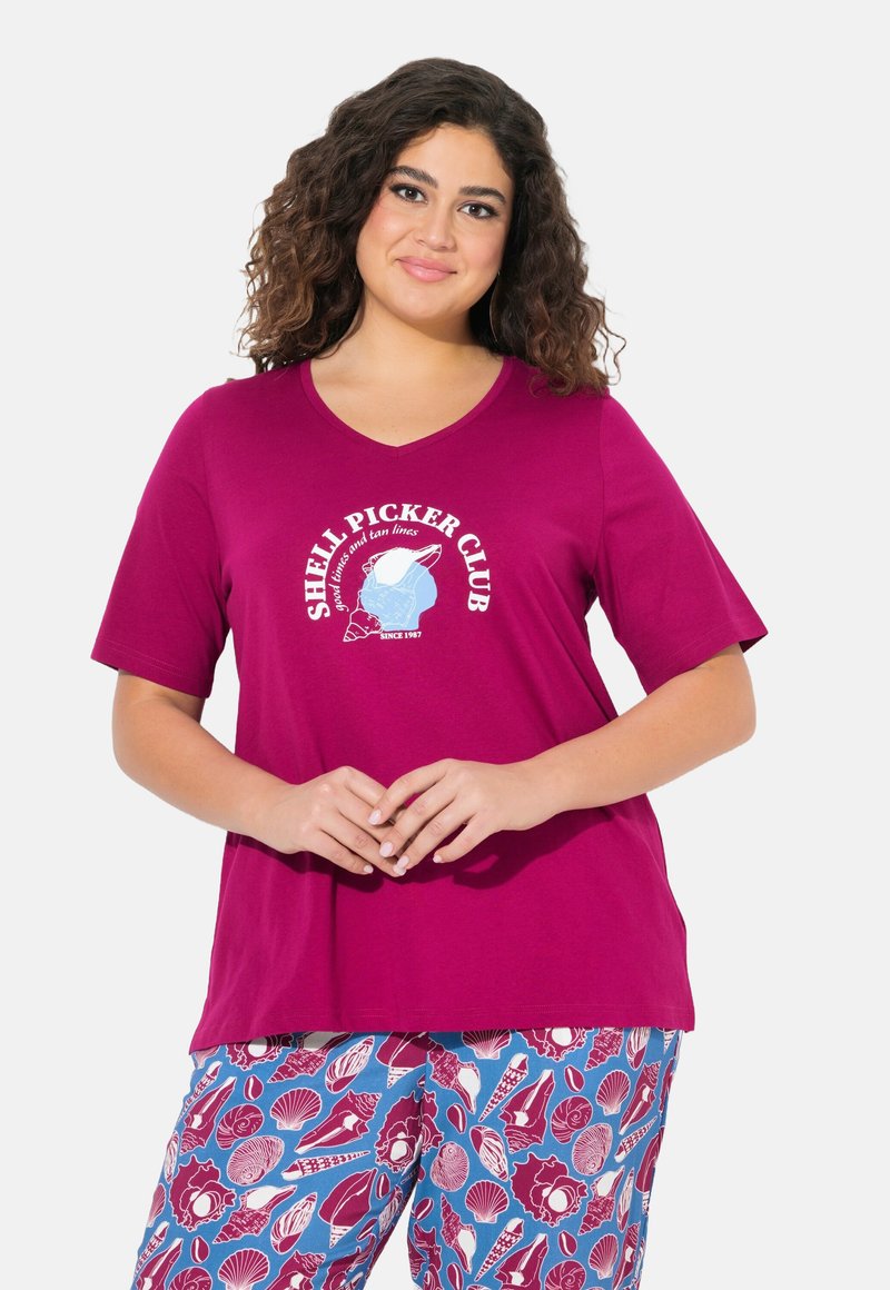Camiseta magenta con cuello en V y gráfico "Shell Picker Club", combinada con pantalones de pijama azul claro que presentan diversos patrones de conchas.