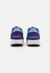 Blue and pink athletic shoes with a suede upper, featuring a light blue accent, white sole, and "diadora" branding on the heel.