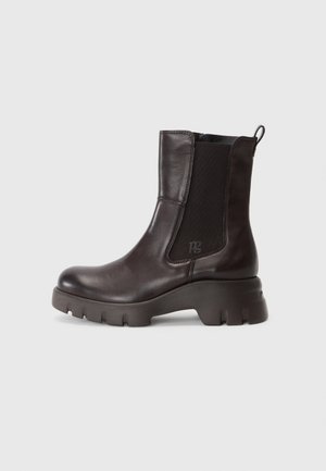Bottines en cuir marron avec des panneaux latéraux élastiques, bout rond, talon épais et semelle texturée. Détail logo discret sur le talon.