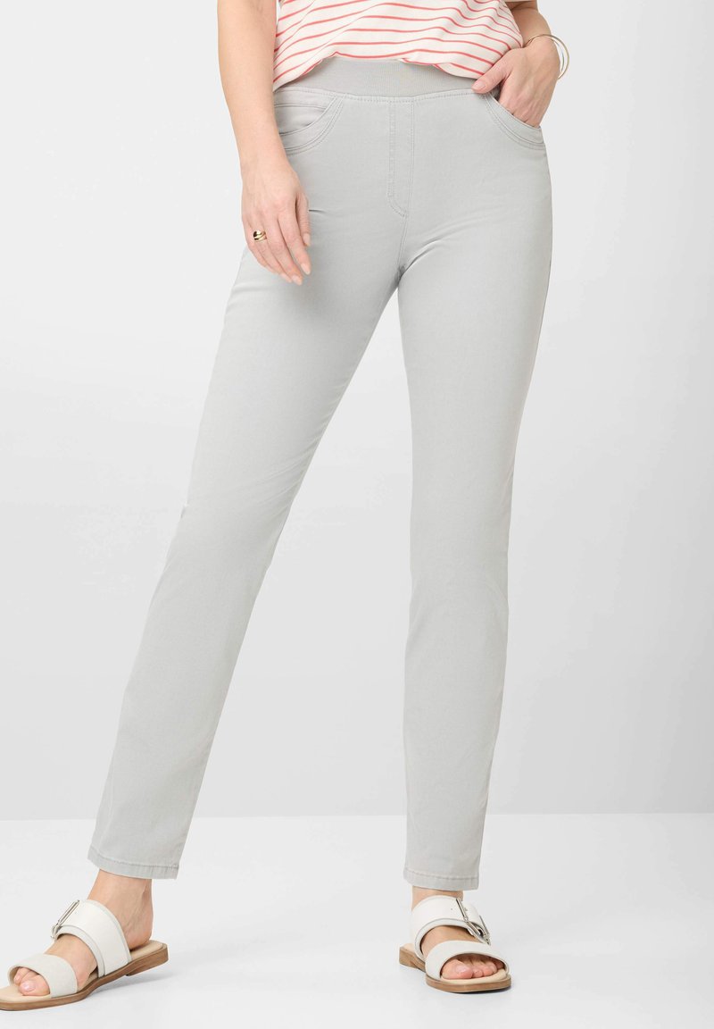 Lichtgrijze pull-on broek met een strakke pasvorm, voorzien van zijzakken, een soepele structuur en een strakke lijnontwerp, gecombineerd met witte sandalen.