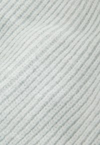 Hellgrauer Strickstoff mit vertikalem Ripp-Design, der ein weiches, flauschiges Aussehen zeigt. Verfügt über eine glatte, gleichmäßige Oberfläche.