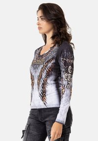 Langärmliges V-Ausschnitt-Shirt mit einem schwarzen und grauen Farbverlauf, auffälligen Flügelgrafiken und Leopardenmuster-Akzenten an den Ärmeln.