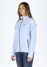 Hellblaue Fleecejacke mit hohem Kragen, Reißverschluss vorne und kontrastierenden marineblauen Akzenten. Verfügt über seitliche Taschen und eine glatte Textur.