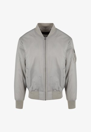 Veste bomber grise avec une texture lisse, col et poignets côtelés, fermeture éclair à l'avant et poches latérales. Dispose d'une poche utilitaire sur la manche gauche.
