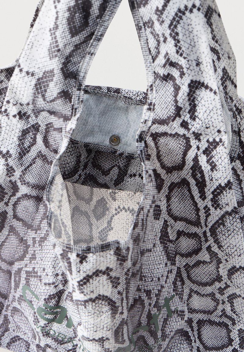 Sac fourre-tout réutilisable avec motif peau de serpent noir et blanc, ouverture supérieure avec fermeture à bouton-pression à l'intérieur.