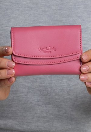 Pink leather wallet with a flap closure, featuring embossed branding and neat stitching. Smooth texture with a rectangular shape.