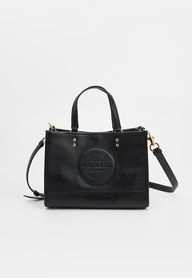 Bolso de mano de piel negra con un acabado texturizado, que cuenta con asas cortas, una correa de hombro desmontable y un logo circular en relieve en la parte frontal.