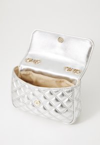 Zilveren gewatteerde handtas met een druksluiting, met een metalen buitenkant en een satijn gevoerde binnenkant. De binnenkant heeft twee goudkleurige ringen.