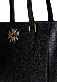Bolso de mano de cuero negro con una superficie texturizada, acentos de hardware dorado y un diseño de logo prominente en la parte frontal.