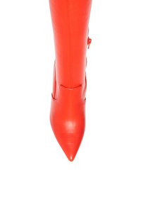 Stivale rosso in pelle alta fino al ginocchio con punta affusolata, texture liscia e zip laterale, caratterizzato da una silhouette aderente.