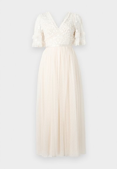 Ελεφαντόδοντο μάξι φόρεμα με κορσάζ από λουλουδάτη δαντέλα, λαιμόκοψη σε σχήμα V, μανίκια μέχρι τον αγκώνα με βολάν και διαφανές φούστα με πιέτες και διακριτικό πουά σχέδιο.