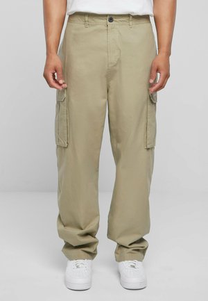 Khaki cargos med sidelommer, løs pasform og letvægtsstof. Har knaplukning og elastiske ankler. Hvide sneakers inkluderet.