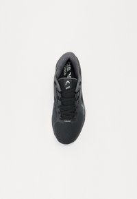Baskets de sport noires avec une tige en maille, une coque de protection texturée au niveau des orteils, des lacets noirs et une semelle en caoutchouc. Présente un logo blanc sur le côté.