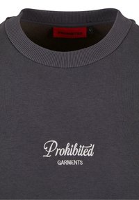 Grå sweatshirt lavet af bomuldsblanding; har ribbet krave og broderet "Prohibited Garments" logo i hvid. Størrelsesmærkat synligt.