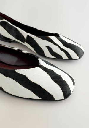 Czarno-białe baleriny w paski zebry wykonane z fakturowanego materiału włochatej skóry, z zaokrąglonym noskiem i minimalistycznym designem.