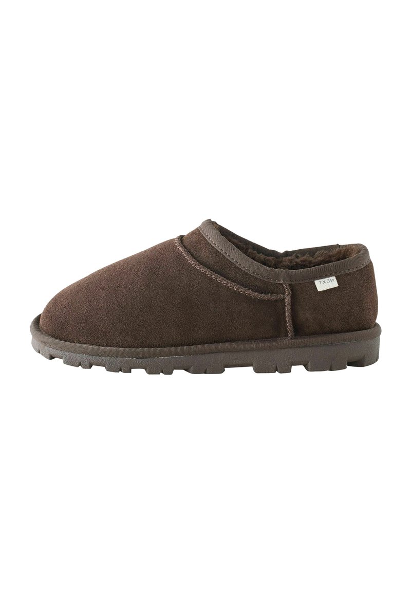 Brune ruskind slip-on sko med en rund tå, blød foring og struktureret gummisål med lav profil og kontrastfremhævede syninger.
