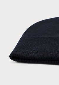 Navy blue knitted beanie made of soft material, featuring a folded hem and ribbed texture. No patterns or additional accents visible.