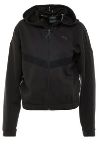 Veste noire à capuche avec fermeture éclair à l'avant, en tissu lisse, présentant une bande texturée à travers la poitrine et des accents latéraux blancs contrastants.