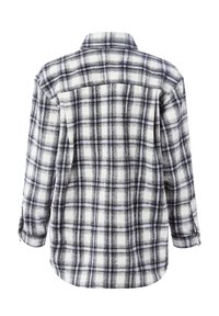 Flannel shirt in black and white plaid, featuring a pointed collar, long sleeves, and a relaxed fit with a curved hemline.
