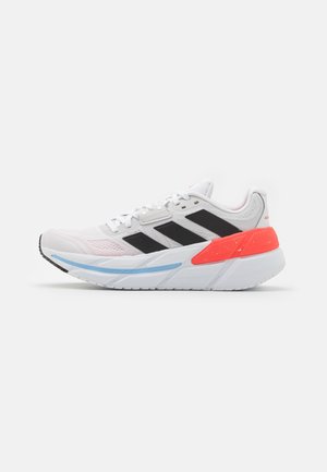 Chaussure de course blanche avec des rayures noires, un support de talon orange, un détail de semelle bleu et des lacets blancs sur un fond uni.