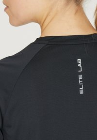 Zwart sportshirt met een gestructureerde stof en een logo met de tekst "ELITE LAB" in het wit op de bovenrug.