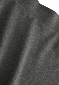Grauer Stoff mit einer glatten Textur, der ein dezentes Melange-Muster zeigt. Das Material fällt weich und reflektiert das Licht in sanften Wellen.