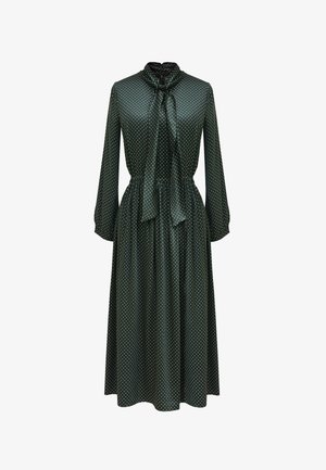 Zielona sukienka w kropki, wykonana z gładkiego materiału, z wysokim dekoltem z wiązaniem, długimi rękawami i rozkloszowanym dołem.