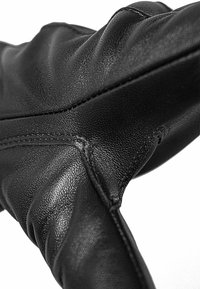 Schwarzer Lederhandschuh mit strukturiertem Oberflächen, ausgestattet mit gerafften Abschnitten und verstärkten Nähten für Langlebigkeit.